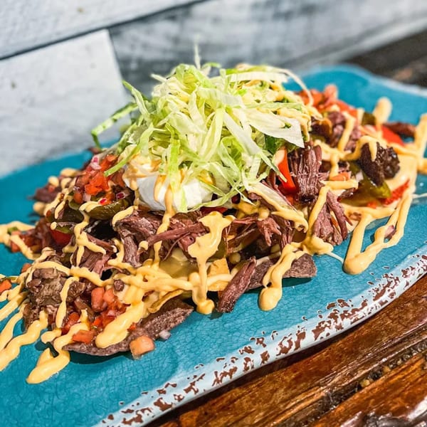 Shore House Tavern's loaded nachos with shredded beef, cheese sauce, pico de gallo, and lettuce.